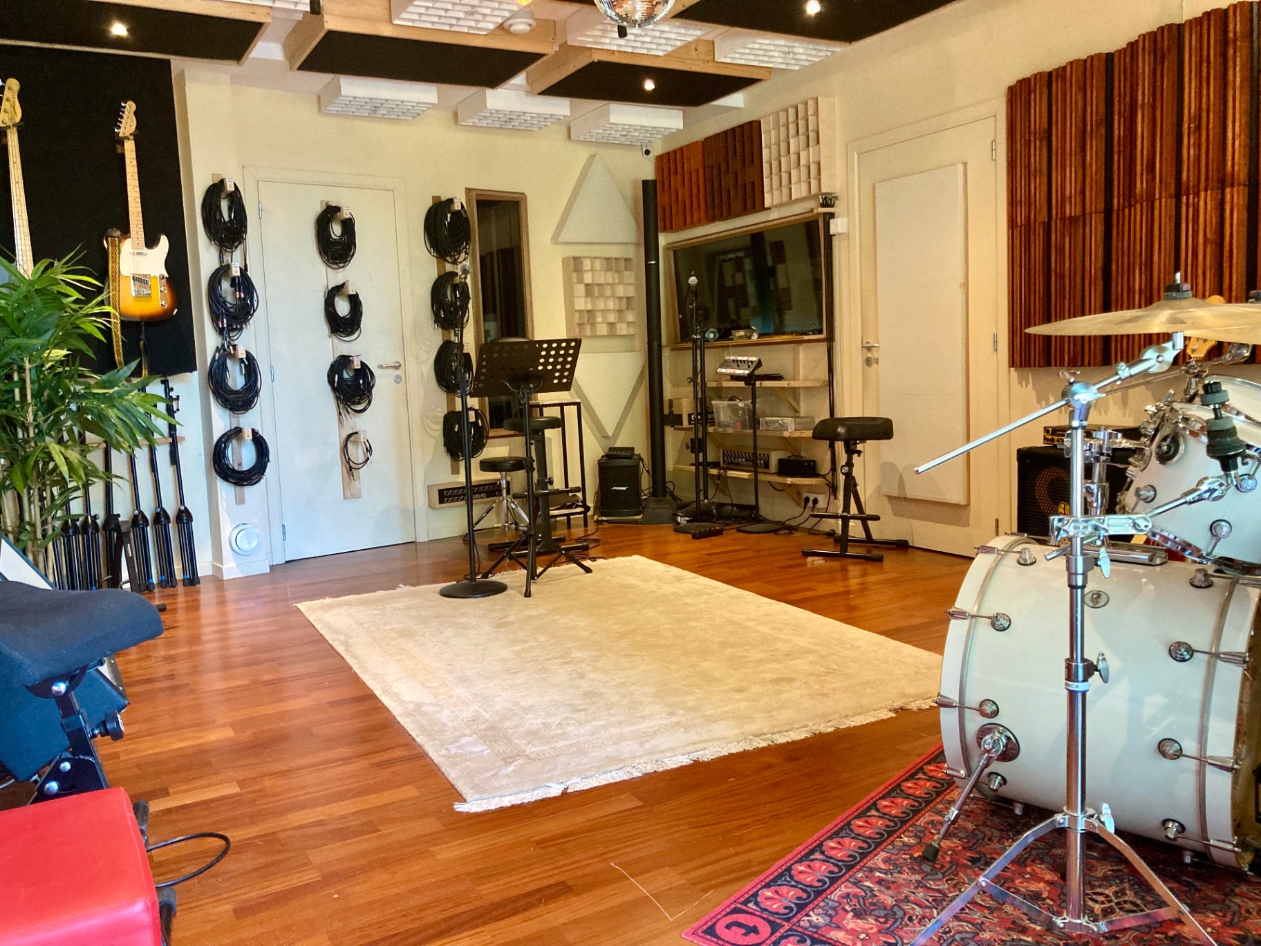 Vue d'ensemble du studio avec guitares, câbles et batterie